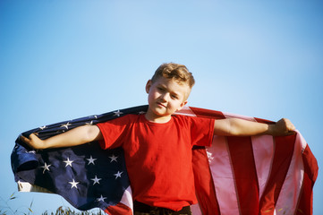 The boy with the flag of the United States . Child patriot holding the flag of America