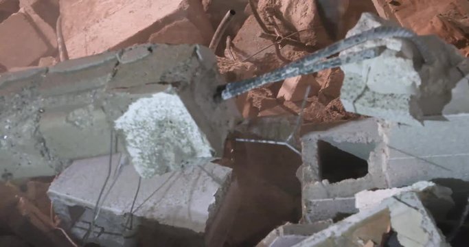 A jackhammer demolishes a cinderblock wall.