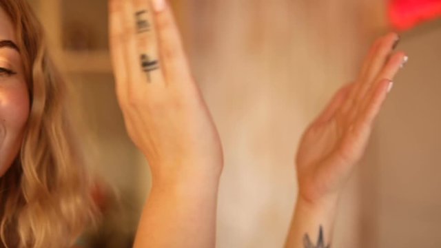 Crop shot in close-up of anonymous woman clapping with hands.