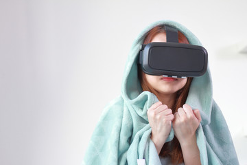 Young woman wearing virtual reality glasses at home.