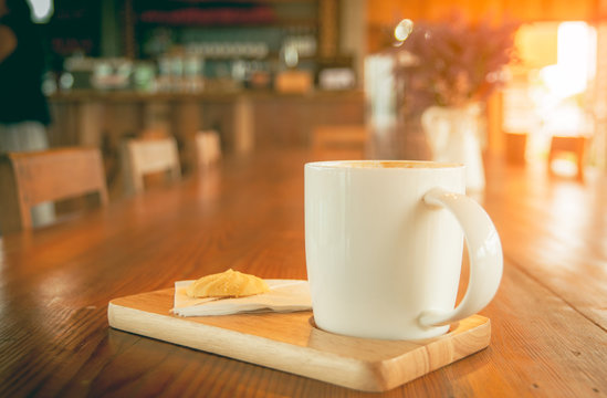 White coffee cup with cookie in coffee shop with vintage tone