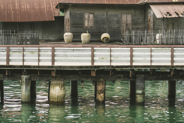 Old wooden house with roofing galvanized in the water