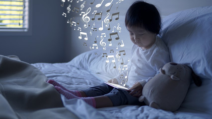 Small Asian chinese toddler sitting on the bed with special effects from ipad