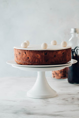 Traditional Christmas dessert, Christmas yule log cake with chocolate cream, cranberry. On stone gray background with Christmas tree branches.