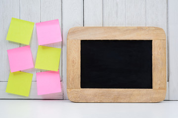 Chalkboard, Alarm clock and blank sticky note, post note on Office desk white wooden vintage background