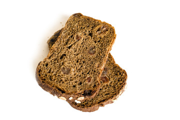 Piece of rye bread with raisins and oat flakes, close-up, isolated on white background, healthy food
