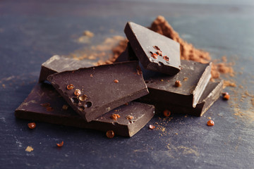 Pieces of delicious dark chocolate on table