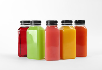 Bottles with delicious colorful juices on white background