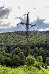 Fototapeta premium Power line tower between forrest with sky.