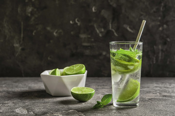 Refreshing beverage with mint and lime in glass on table