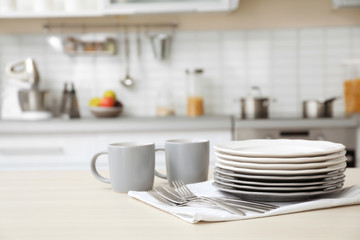 Tableware and blurred view of kitchen interior on background