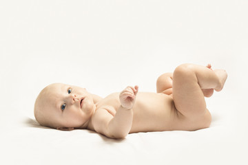 beautiful child without clothes lies on a white background