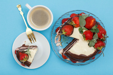 Homemade chocolate cake decorated with fresh strawberries and cup of coffee