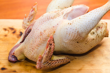 Farm raw gutted chicken on a wooden cutting board