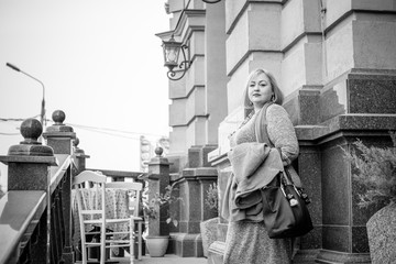 A woman of plus size, American or European appearance walks in the city enjoying life. A young lady with excess weight, xxl size at the center of the city. Natural beauty 