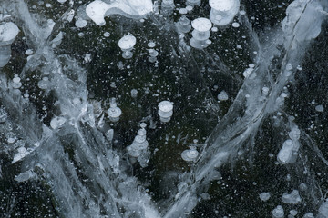 Obraz na płótnie Canvas Cracks in the ice mix with ice bubbles in Lundy Lake