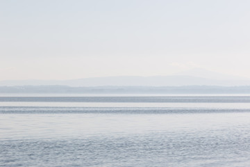 Minimalist, graphic view of a lake, with stripes of different sh