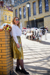 A woman of plus size, American or European appearance walks in the city enjoying life. A young lady with excess weight, xl size at the center of the city. Natural beauty 