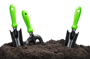 various garden tools in soil isolated on white background