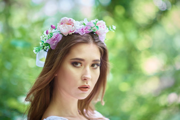 Young womqn in a white dress walking in a forest