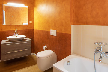 Bathroom with modern finishes and orange walls