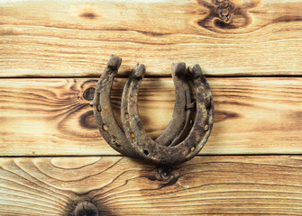 old rusty horseshoes on wooden board