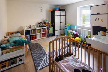 Children's bedroom with many books and toys