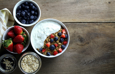Healthy breakfast, Bowl of yogurt with granola and Fresh fruit on Wood background