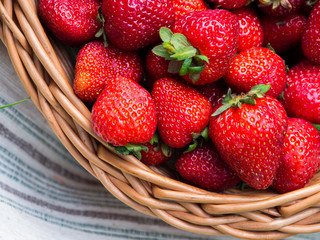 Juicy, fresh, ripe strawberries in a wicker basket. Basket with strawberries on the background of green grass.