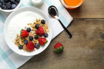 Healthy breakfast, Bowl of yogurt with granola and Fresh fruit on Wood background
