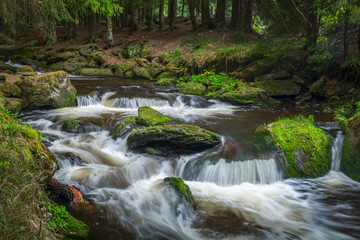 Beautiful waterfall in green Spruce forest with big rocks around, Hamersky potok in Sumava, Czech Republic