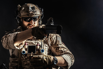 Special forces soldier with rifle on dark background