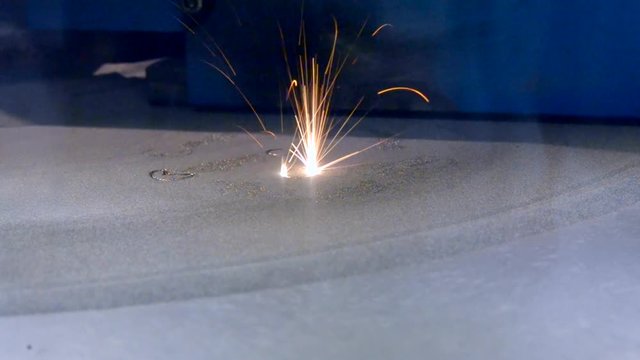 3D printer printing metal. Laser sintering machine for metal. Metal is sintered under the action of laser into desired shape in working chamber close-up. Progressive DMLS, SLM, SLS additive technology