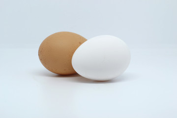 Two eggs, one white and the other brown