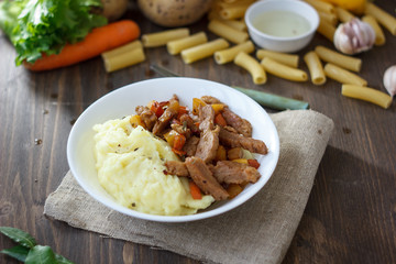 Soy meat with potato puree over kitchen table.