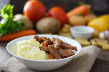 Soy meat with potato puree over kitchen table.
