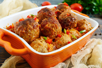 Juicy meatballs in a spicy tomato sauce on a wooden table. Dish from minced meat.
