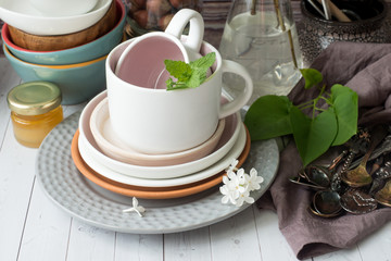 Many different empty tableware. Bouquet of white lilac. Wood background dark napkin