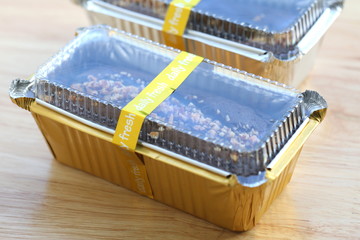 Chocolate cake in aluminum foil box packaging.