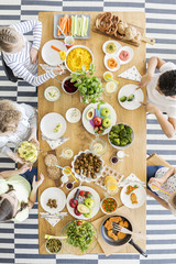Top view on table with food. Group of kids eating healthy dinner with vegetables