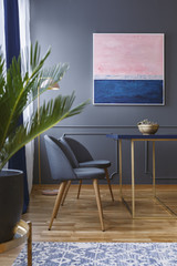 Real photo of dining room interior with two chairs standing in front of a table on a wooden floor...