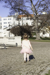 Toddler dressed in Balerina skirt walking in a Park