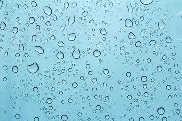 Drops of rain on the tinted windshield of the car. texture