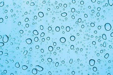 Drops of rain on the tinted windshield of the car. texture
