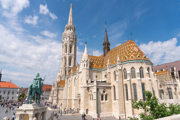 Fototapeta na wymiar Matthias Church, a church located in Budapest, Hungary, in front of the Fisherman's Bastion at the hill of Buda's Castle District with tourist and hungarian people.