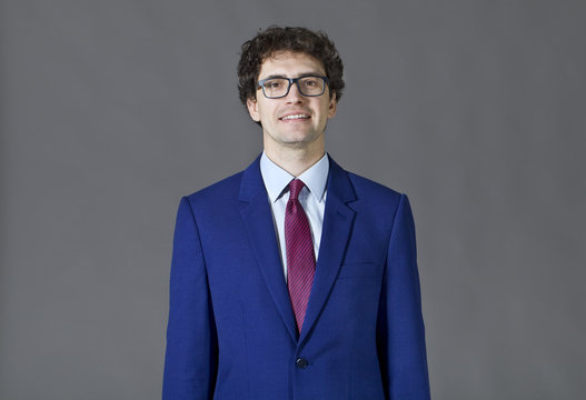 Honest guy wearing a blue jacket and glasses smiling