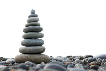 a pyramid of stones on a pebble beach isolated on a white background