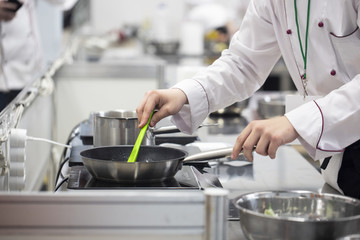 Fototapeta na wymiar Cook preparing food in a restaurant kitchen