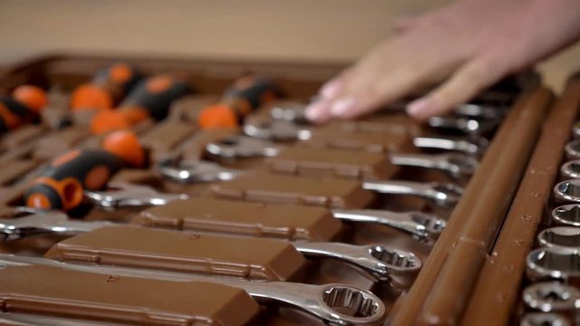 Girl builder chooses tools in toolbox with her hand, repairing conception