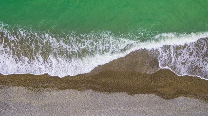 Poster de jardin Côte Top-down drone view of the seacoast with the surf and the pebble beach  